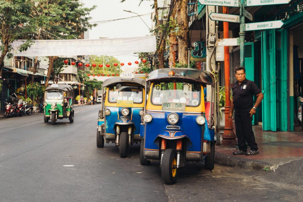 Trois tuk-tuks colorés sur une rue de Bangkok