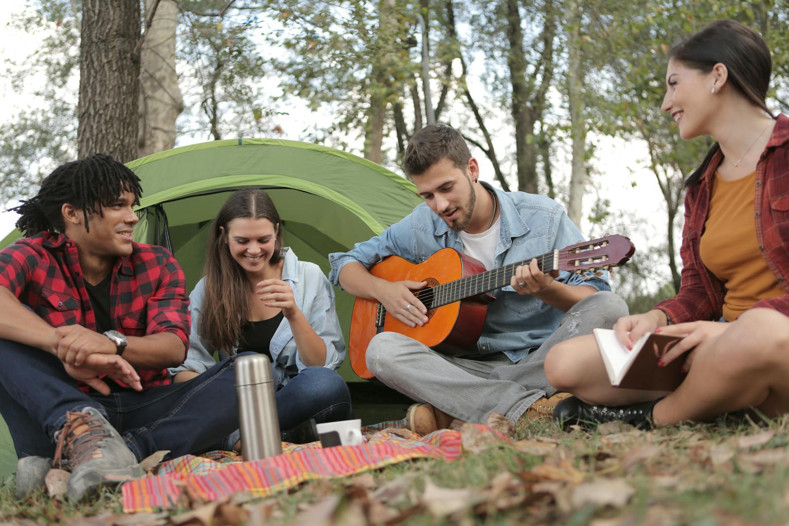 Trois amis jouent de la guitare en pleine nature