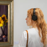Femme avec un casque devant une peinture