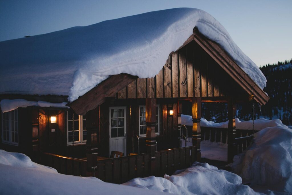 Un chalet en bois sous la neige