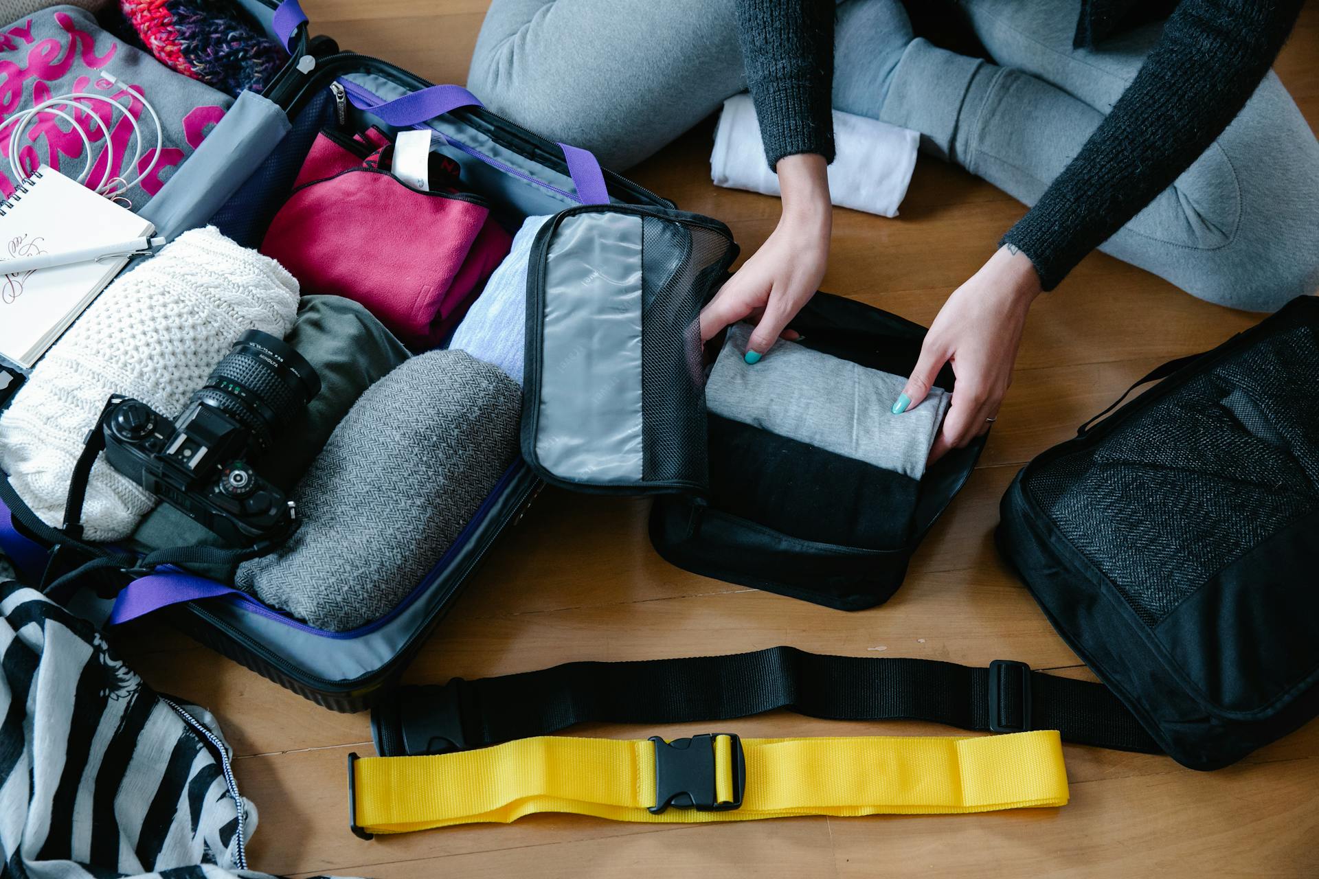Une personne organise des vêtements dans une valise